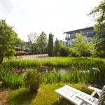 A white deckchair in the hotel garden in front of the pond