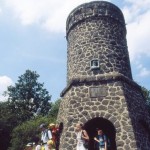 People visiting a stone-covered tower