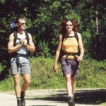 Hikers with backpacks walking on a road