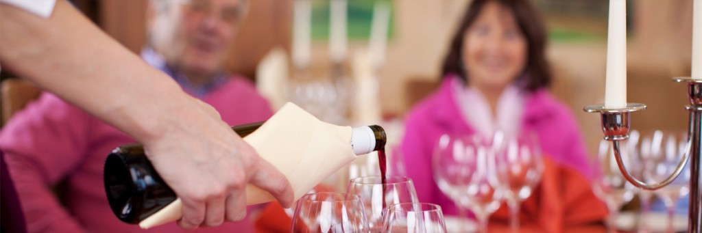 Person pouring wine into a glass